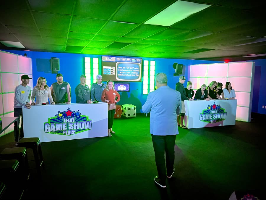 Two teams at the podiums facing the host